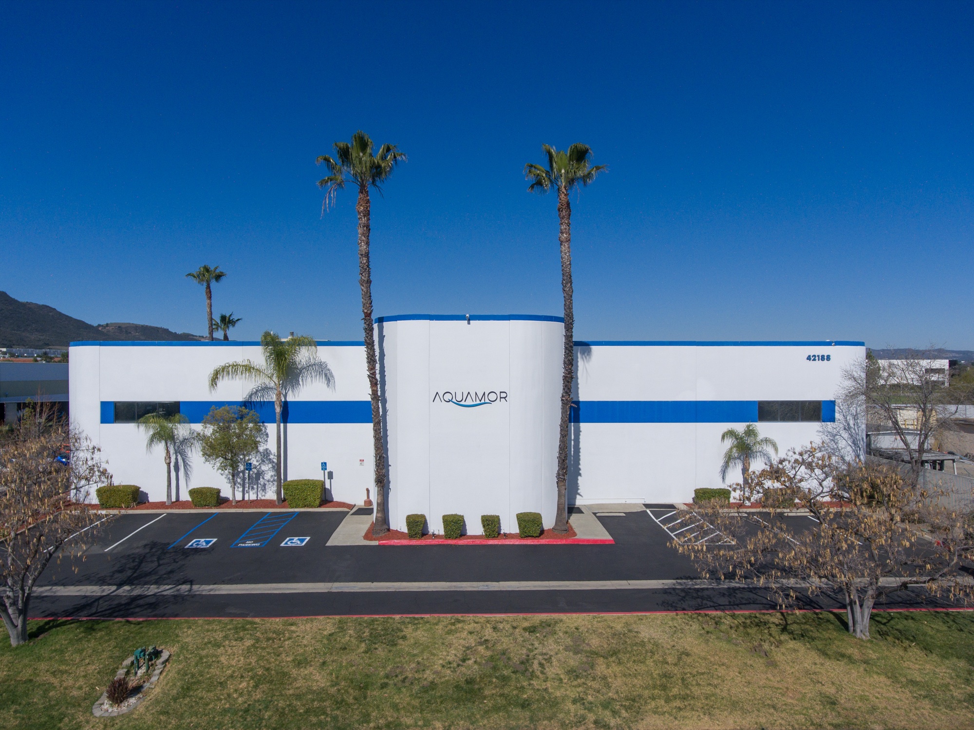 Aquamor's Temecula, California facility — white-and-blue building with the Aquamor wordmark under a clear sky